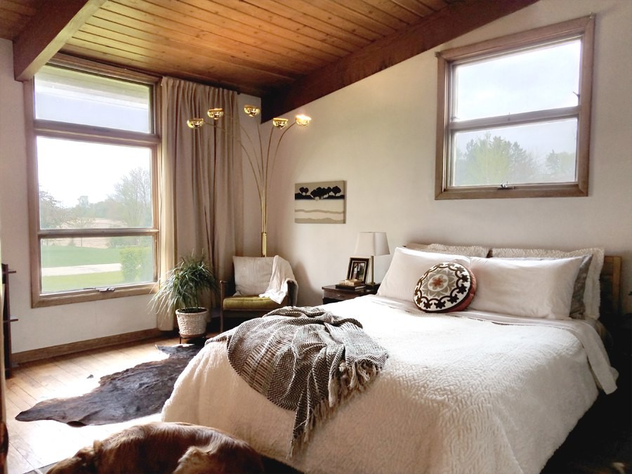 Không gian còn lại của căn phòng là một giường ngủ cỡ lớn. Bộ ga gối kem trắng xốp cùng tấm thảm trải màu trầm tạo điểm nhấn cho căn phòng. không gian ấn tượng