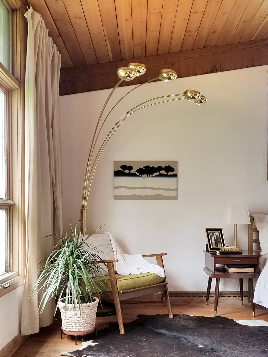 Góc đọc sách cạnh cửa sổ được bố trí thêm cây xanh và bộ đèn ấn tượng góc đọc sách