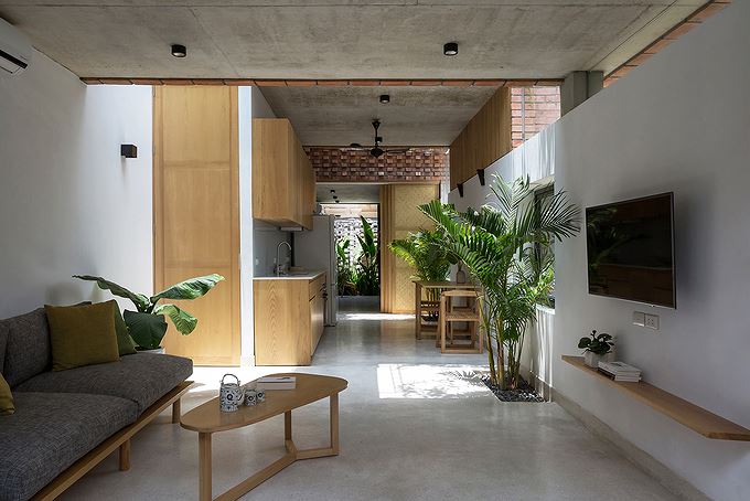 Mặc dù không gian nhà dài và hẹp nhưng nhờ độ cao của trần tầng 1 kết hợp với giếng trời đã góp phần tạo cảm giác thoáng đãng và dễ chịu Nhà phố hiện đại