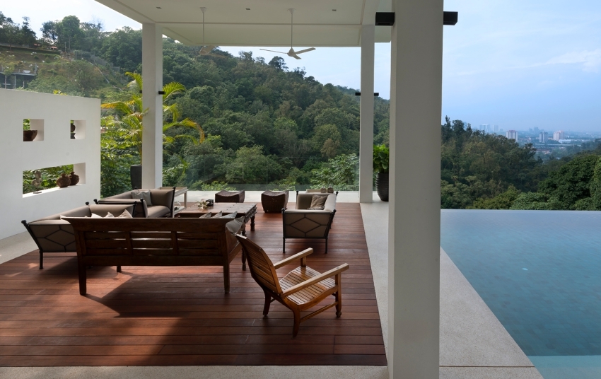 Chụp cận cảnh sảnh thư giãn gồm bàn ghế đặt trên sàn gỗ, bên cạnh là bể bơi lộ thiên xây biệt thự đẹp