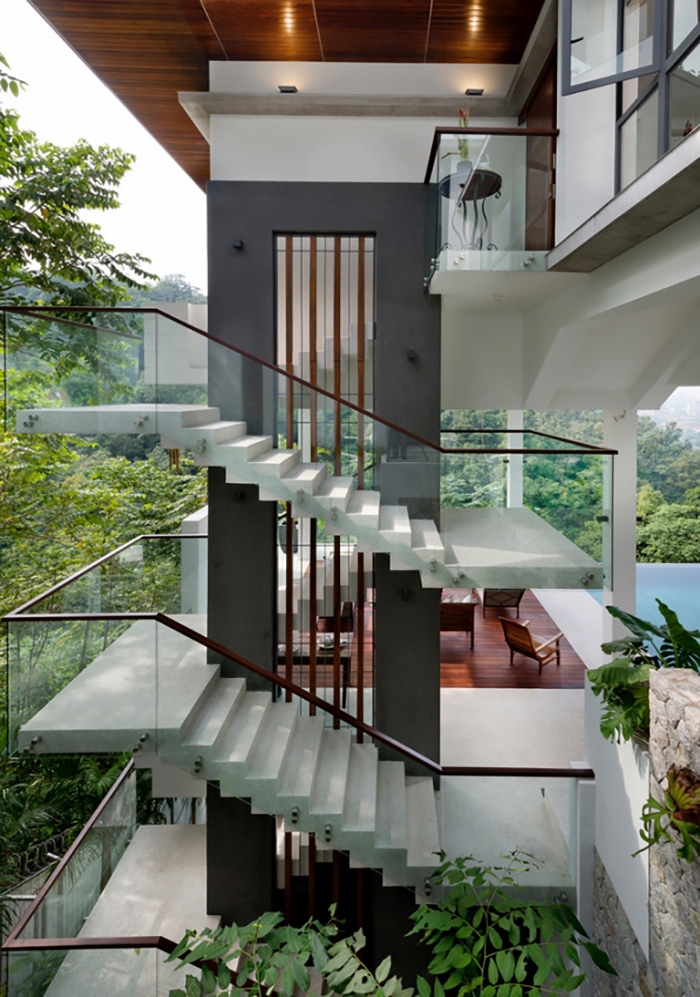 Ảnh chụp góc chéo từ trên xuống nhìn rõ cầu thang của tầng 2 và tầng 3, phần lan can được ốp kính cầu thang đẹp