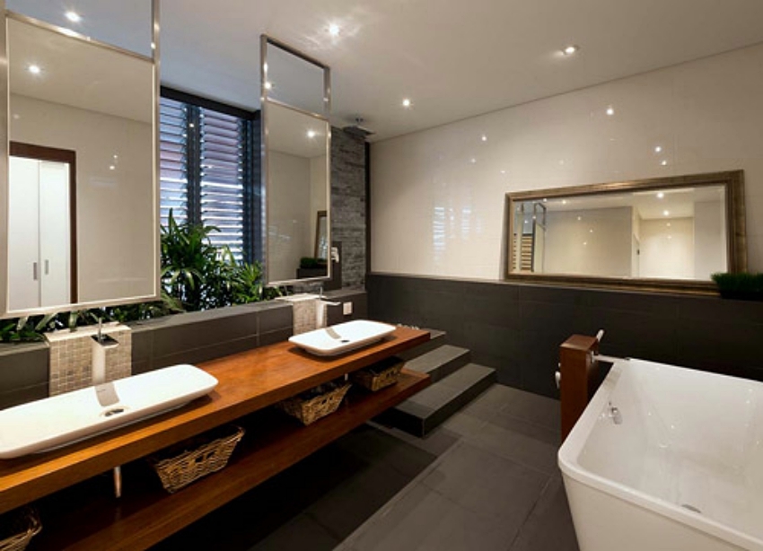 Cận cảnh phòng vệ sinh, với bồn rửa tay đôi bố trí trên kệ gỗ dài, trên có lắp gương lớn, bên cạnh là một phần bồn tắm nội thất nhà đẹp