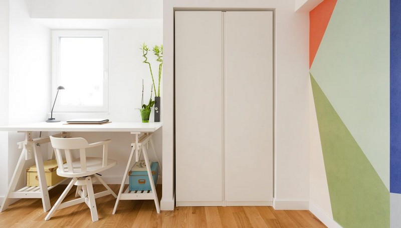 Phòng làm việc gồm bàn làm việc thiết kế trẻ trung đặt cạnh cửa sổ, bên cạnh là tủ lưu trữ cao sát tường. Tường trong phòng sơn những mảng hình học nhiều màu phòng làm việc đẹp