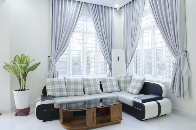 Trong ảnh là phòng khách đặt tại tầng 1 của ngôi nhà phố với cửa sổ kính được lắp thêm khung sắt bảo vệ thiết kế không gian sống ấn tượng