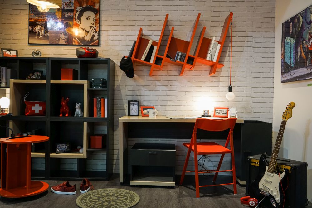 Các gam màu nóng như đỏ, cam khiến không gian ấm áp thêm bội phần. bàn, ghế và kệ màu cam