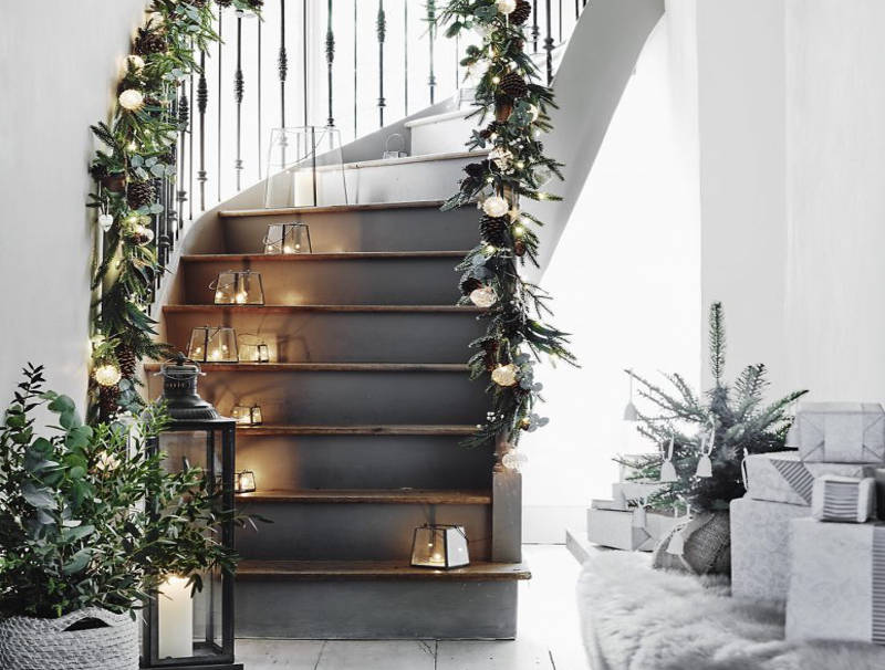 Khung cảnh Giáng sinh Bắc Âu được tạo nên từ đèn dây và nến. nến đặt trên bậc cầu thang và đèn dây treo ở lan can cầu thang