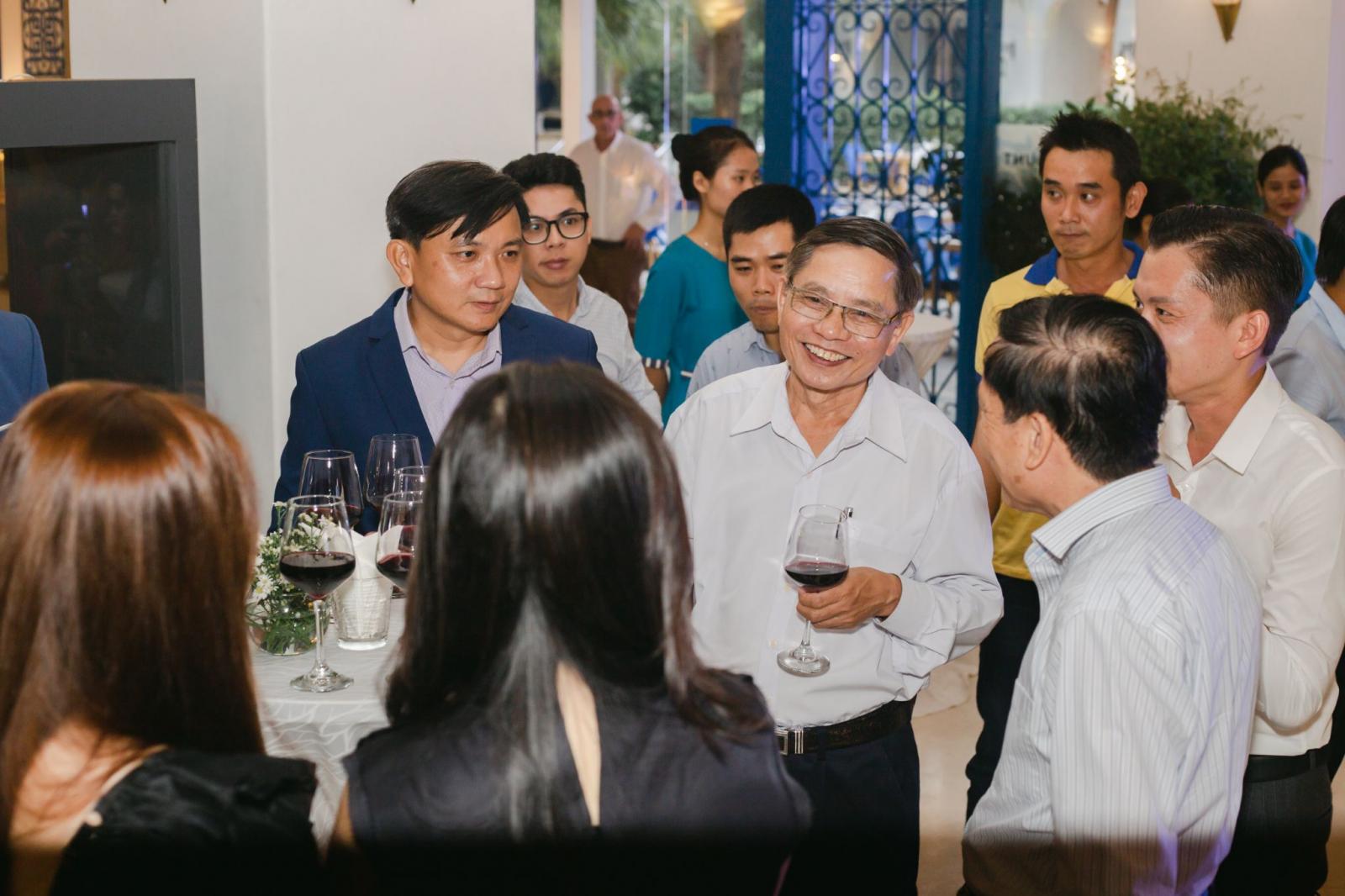 nhiều người đứng trò chuyện trong bữa tiệc