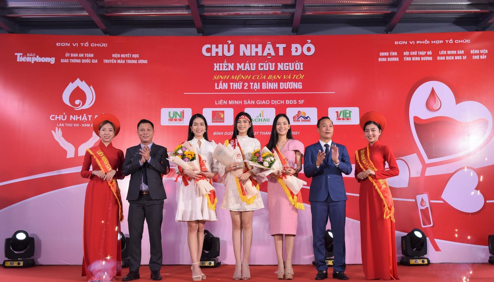 nhiều người đang đứng trên sân khấu màu đỏ