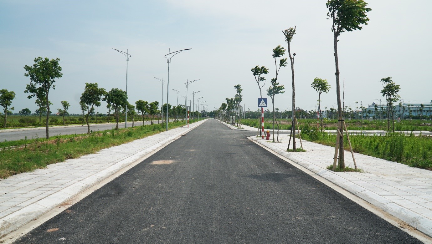 đường đi giữa khu đất trống và cây xanh