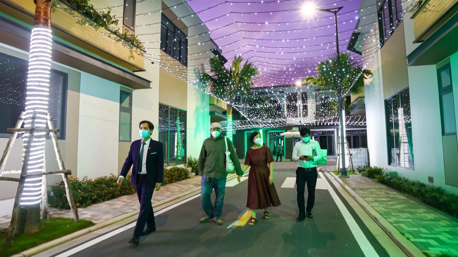A group of people walking down a sidewalkDescription automatically generated with low confidence